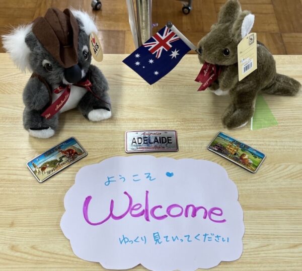 コアラとカンガルーのぬいぐるみが机の上に乗っていて中央に「ようこそ Welcome」と書かれた紙が置かれている